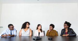 A diverse group of professionals having a meeting in a modern office setting. Teamwork and collaboration.