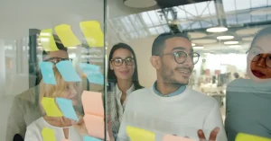 A diverse team collaborating in a modern office using colorful sticky notes.