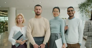 Team of professionals standing confidently in a bright, modern office environment.