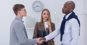 Two diverse business professionals shaking hands, symbolizing partnership and collaboration.