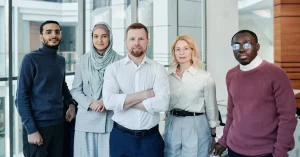 A diverse group of professionals posing confidently in a modern office environment.