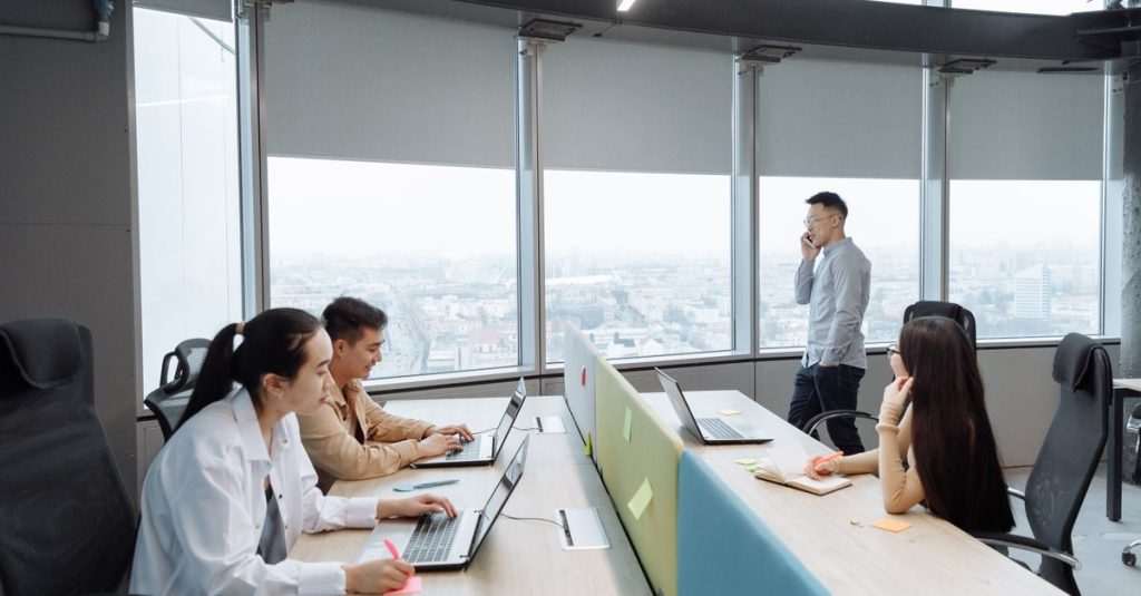 Nhóm làm việc trong văn phòng hiện đại với khung cảnh thành phố phía sau