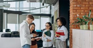 A diverse team of professionals collaborates in a modern office setting, exchanging ideas.
