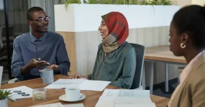 Professional multicultural team having a discussion in a contemporary office environment.