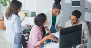 A diverse team engaged in a lively discussion in a modern office setting, fostering collaboration and teamwork.